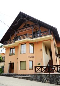a house with a balcony on top of it at Vila Man in Sovata
