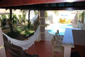 um pátio com uma rede de descanso, uma mesa e uma piscina em Casa Magnífica em Olímpia mais 38 fotografias