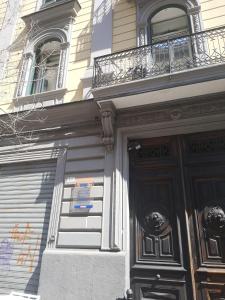 a building with a black door and a balcony at Suite Ottocento napoletano in Naples