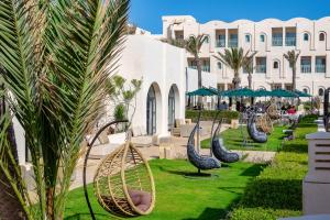 um resort com um monte de cadeiras de vime num parque em Ulysse Djerba Thalasso & SPA em Houmt Souk