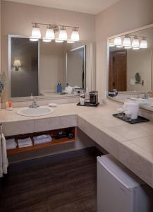 Un baño con lavabo y un espejo grande. en Bay Club Hotel and Marina, en San Diego