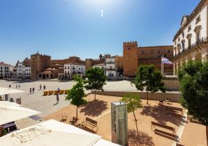 a city square with tables and benches and buildings at Apartamentos Plaza Mayor 35 in Cáceres