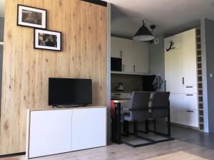 ein Wohnzimmer mit einem TV und einem Tisch mit Stühlen in der Unterkunft Apartament Bielany Oczapowskiego in Warschau