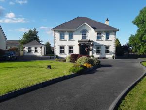 a white house with a driveway at Doonard Manor B&B in Craughwell
