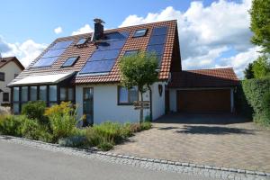 une maison avec beaucoup de panneaux solaires sur son toit dans l'établissement Ferienwohnung Jasmin & Alex, à Mühlhausen-Ehingen
