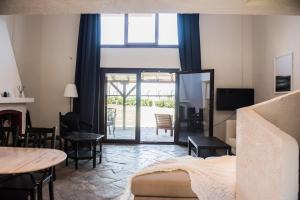 Un dormitorio con una cama y una mesa y sillas. en White Blossom Villa #Fourka, en Skála Foúrkas