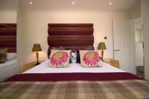 a bedroom with a large bed with two pillows at The Marlfield in Bellshill