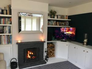 a living room with a fireplace and a television at The Cornish Retreat in Bude