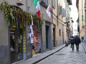 Eine Straße mit Leuten, die eine Straße mit Flaggen entlang laufen in der Unterkunft Sant'Antonino Apartments in Florenz