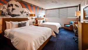 a hotel room with two beds and a couch at The Rushmore Hotel & Suites; BW Premier Collection in Rapid City +41 photos