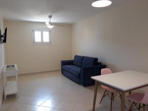 a living room with a blue couch and a table at Monolithos Villas in Kipri