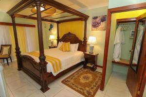 a bedroom with a canopy bed and a mirror at Rayon Hotel in Negril