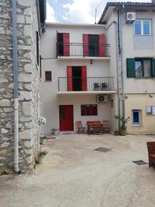 Edificio blanco con puertas rojas y balcón en Apartment Ana 2 en Sveti Filip i Jakov