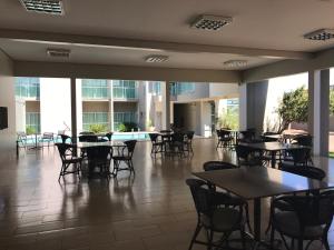 uma sala de jantar com mesas e cadeiras num edifício em Oásis Hotel em Araguaína