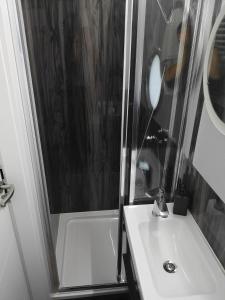 W łazience znajduje się umywalka oraz prysznic z lustrem. w obiekcie Apartament Na Wodzie w mieście Ruciane-Nida