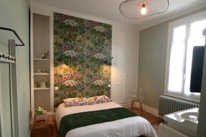 1 dormitorio con 1 cama y papel pintado con motivos florales en La Lambertine & Spa, en Saumur