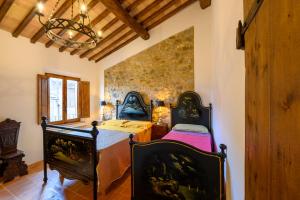 a bedroom with two beds and a stone wall at CASA DEL MEDIOEVO in San Gimignano