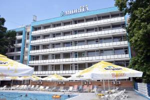 un hôtel avec des parasols en face d'une piscine dans l'établissement Hotel Miorita Neptun, à Legian