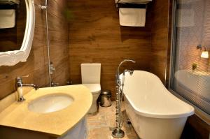 La salle de bains est pourvue d'un lavabo, d'une baignoire et de toilettes. dans l'établissement Hotel Konak, à Momtchilgrad