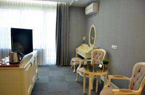 Cette chambre dispose d'une coiffeuse, d'un miroir et d'une coiffeuse. dans l'établissement Hotel Konak, à Momtchilgrad