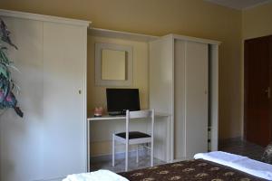 a bedroom with a desk with a computer and a chair at Hotel Costa Jonica in Sellia Marina