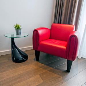 a red chair sitting next to a glass table at City Hotel Bergen op Zoom in Bergen op Zoom