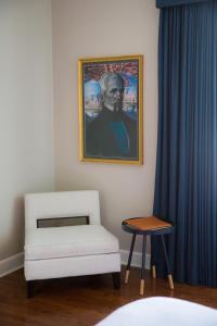 a room with a chair and a painting of a man at The Germantown Inn in Nashville