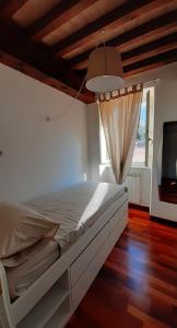 1 dormitorio con 1 cama grande y TV en il nido dell'arancio, en Carrara