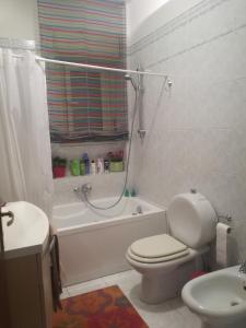 a bathroom with a toilet and a tub and a sink at Ai piedi del Vulcano in Gravina di Catania
