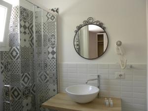 a bathroom with a sink and a shower with a mirror at acquaesale rooms in Porto Cesareo
