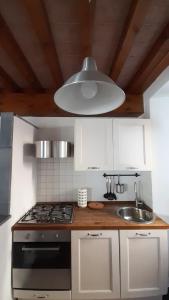 a kitchen with a stove and a sink and a light at il nido dell'arancio in Carrara