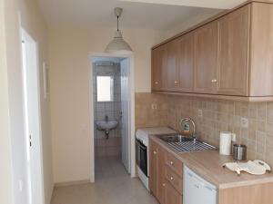 a kitchen with wooden cabinets and a sink and a sink at Monolithos Villas in Kipri