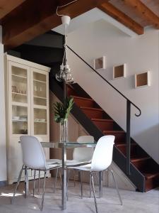 a dining room with a table and chairs and a staircase at il nido dell'arancio in Carrara