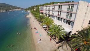 a view of a beach with palm trees and a building at Vila Mila in Vela Luka