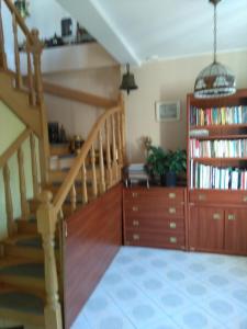 a living room with a staircase and a book shelf at AJ KWATERY in Gdynia
