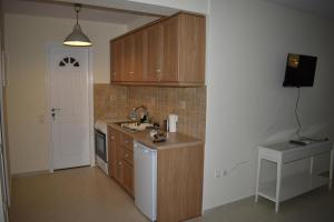 a kitchen with wooden cabinets and a sink at Monolithos Villas in Kipri