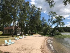 a group of lounge chairs on a sandy beach at Gränna Strandhotell in Gränna