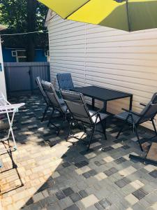a patio with a table and chairs and an umbrella at Дача у моря in Vapnyarka
