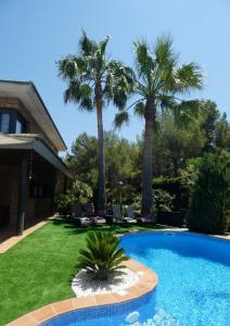 una piscina en un patio con palmeras en Washingtonia Villa near Sitges, en Canyelles