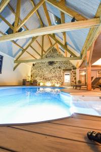 una piscina en un edificio con una pared de ladrillo en La Brocherie, en Magny-le-Désert