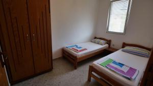 um pequeno quarto com 2 camas e uma janela em Familien Apartment Zeno em Ulcinj