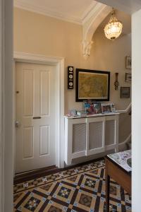 a hallway with a white door and a patterned floor at Cliftons Guest House in Truro