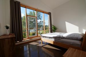 a bedroom with a bed and a large window at Gästewohnung Hardinghaus am Teich in Warendorf