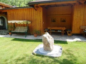 a patio with a bench and a table in a yard at Pension Wald in Faistenau