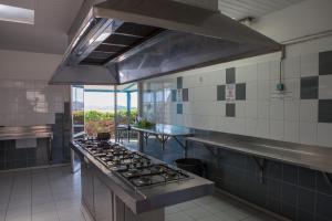 a kitchen with a stove top oven in a kitchen at Auberge Jeunesse Nouméa in Noumea