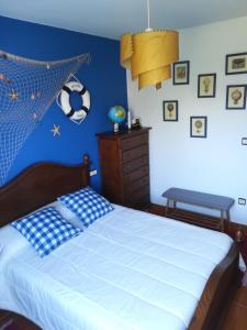 1 dormitorio con 1 cama con pared azul en Apartamento A Atalaia, en Laxe