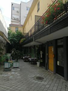 Centar Novi Sad-Apartman No 1 في نوفي ساد: ساحة مبنى به طاولات وكراسي
