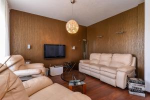Il comprend un salon avec des canapés et une télévision à écran plat. dans l'établissement Super Premium Two Bedroom Suite on Vitosha Boulevard, à Sofia