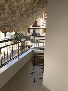 une chambre avec un balcon avec une table et une chaise dans l'établissement Coco Deluxe Apartment city center of Heraklion, à Héraklion