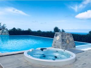 a swimming pool with a jacuzzi tub in front of a swimming pool at Green Park Hotel & Residence in Bagnara Calabra